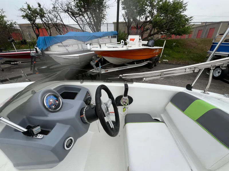 Slide: The Image of Interior view of a 2021 Tahoe T16 boat with steering wheel and seating. - 23