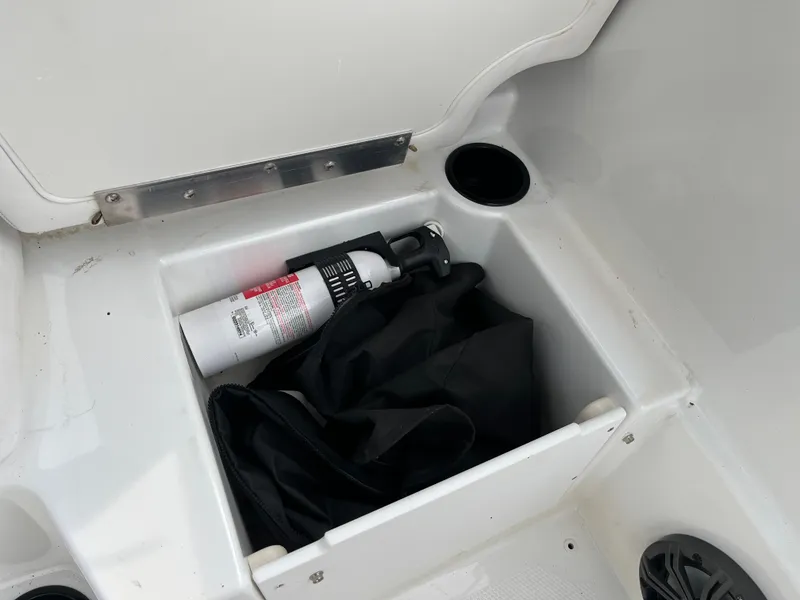 Slide: The Image of Storage compartment in 2021 Tahoe T16 boat with fire extinguisher and black cover. - 26