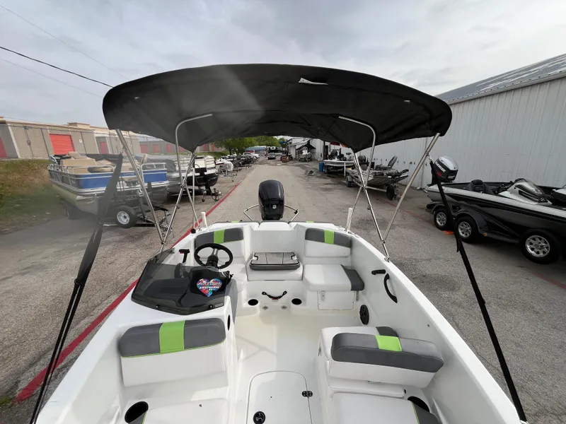 Slide: The Image of 2021 Tahoe T16 boat with canopy, parked in a marina, surrounded by other boats. - 27
