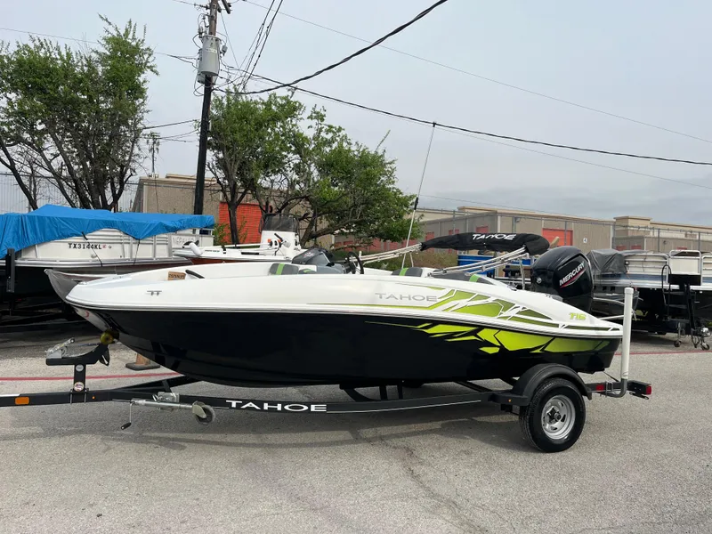 Slide: The Image of 2021 Tahoe T16 boat on trailer, parked outdoors, with vibrant green accents. - 3