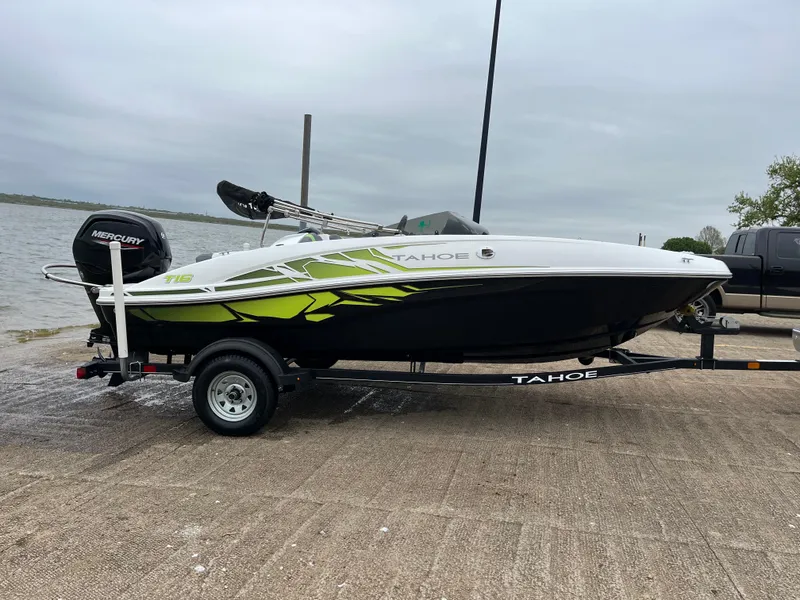 Slide: The Image of 2021 Tahoe T16 boat on trailer by lakeside, featuring sleek design and vibrant graphics. - 33