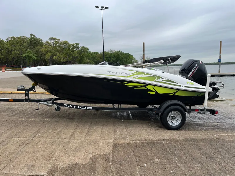 Slide: The Image of 2021 Tahoe T16 boat on trailer by lakeside, featuring sleek design and vibrant accents. - 42