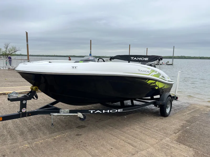 Slide: The Image of 2021 Tahoe T16 boat on trailer by a lake, overcast sky. - 45
