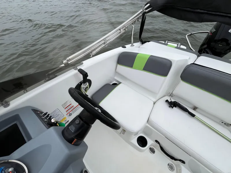 Slide: The Image of 2021 Tahoe T16 boat interior with white and green seating, steering wheel, and controls. - 47