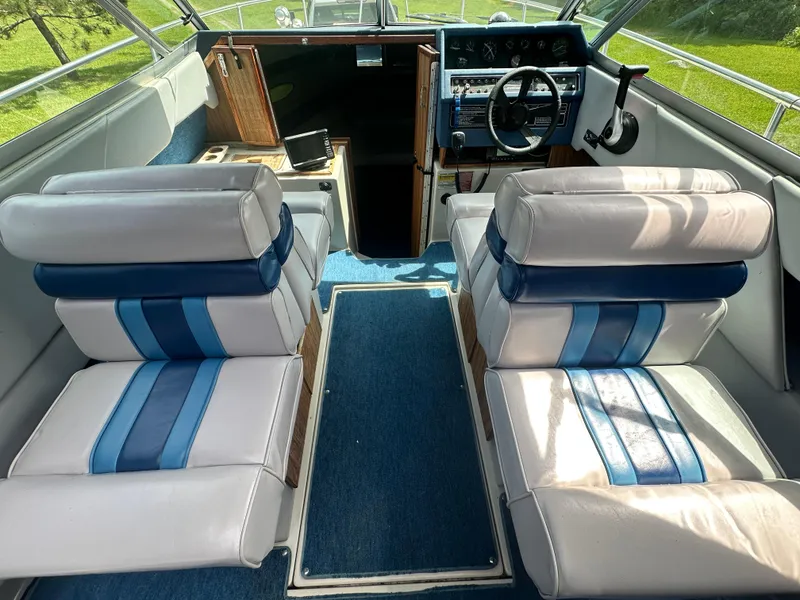 Slide: The Image of Interior of a 1988 Sea Ray 230 Cuddy boat with blue and white seating. - 4