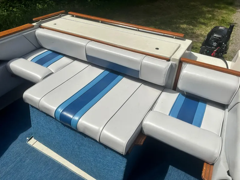 Slide: The Image of 1988 Sea Ray 230 Cuddy boat interior with blue and white cushioned seating. - 6