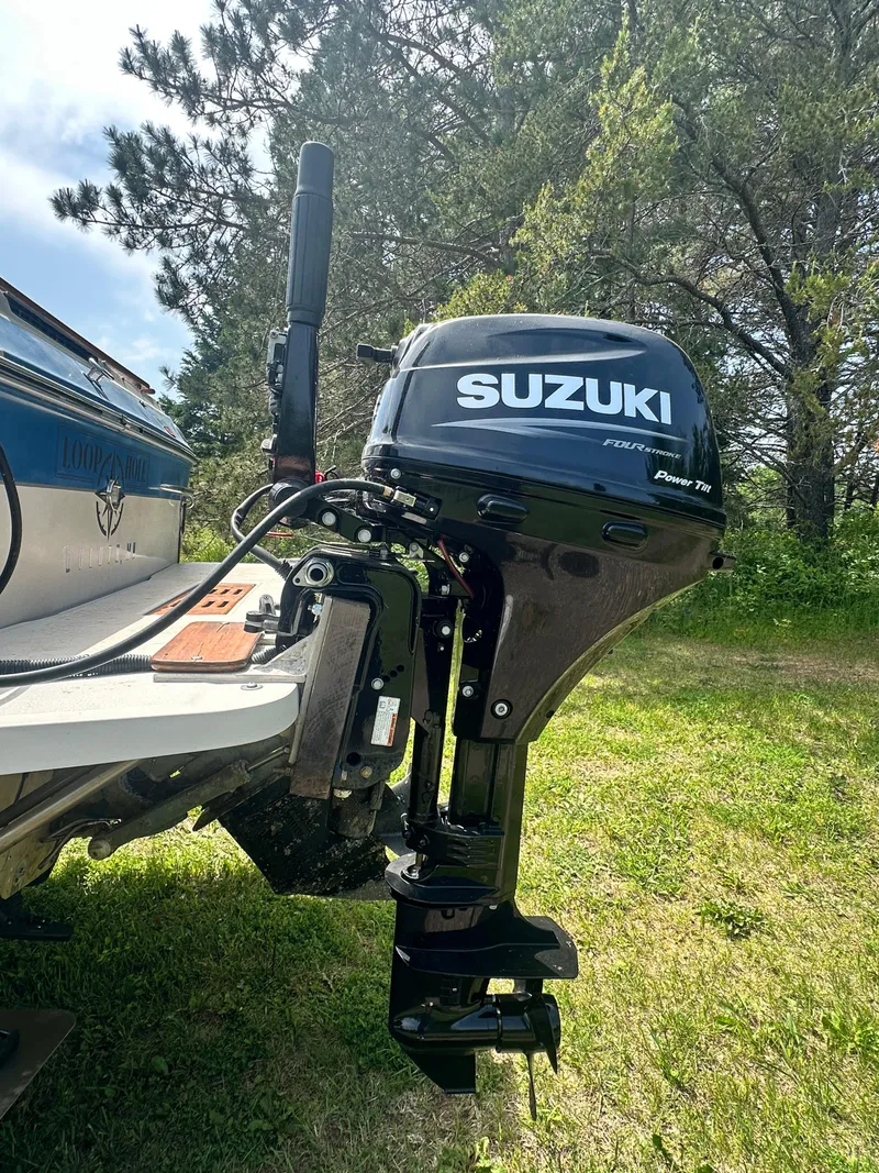 Slide: The Image of 1988 Sea Ray 230 Cuddy with Suzuki outboard motor on grassy area. - 8