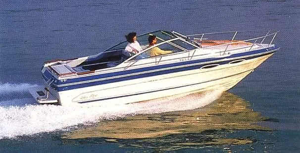 Slide: The Image of 1988 Sea Ray 230 Cuddy cruising on water with two passengers onboard. - 9
