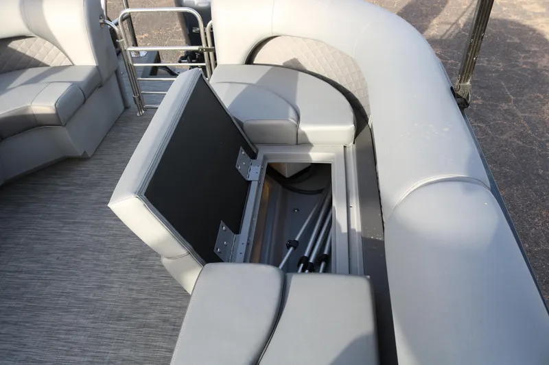 Slide: The Image of 2021 Bennington L22 pontoon boat with open storage compartment and gray seating. - 21