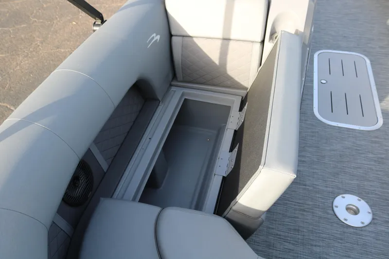 Slide: The Image of 2021 Bennington L22 boat interior with open storage compartment and gray seating. - 25