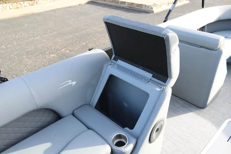 Slide: The Image of 2021 Bennington L22 boat interior with open storage compartment and cup holder. - 27