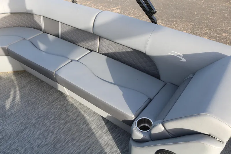 Slide: The Image of 2021 Bennington L22 boat interior with gray cushioned seating and cup holder. - 28
