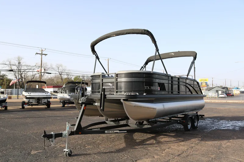 Slide: The Image of 2021 Bennington L22 pontoon boat on trailer in outdoor dealership lot. - 3