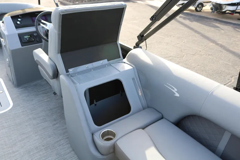 Slide: The Image of 2021 Bennington L22 boat interior with open storage compartment and cup holder. - 32