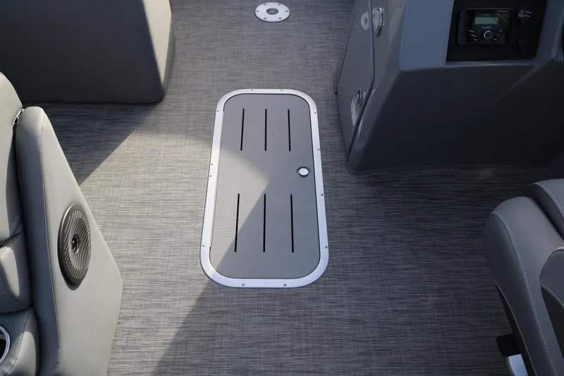 Slide: The Image of 2021 Bennington L22 boat interior with gray flooring and storage compartment. - 42