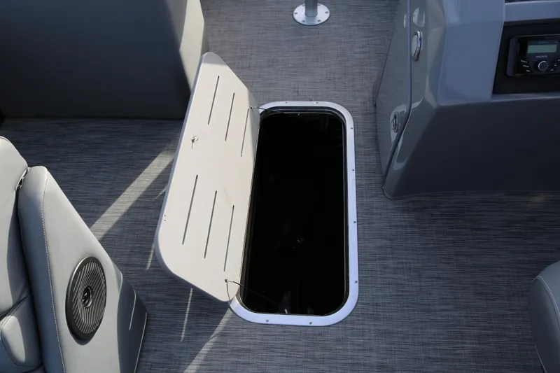 Slide: The Image of 2021 Bennington L22 boat interior with open storage compartment on gray flooring. - 43