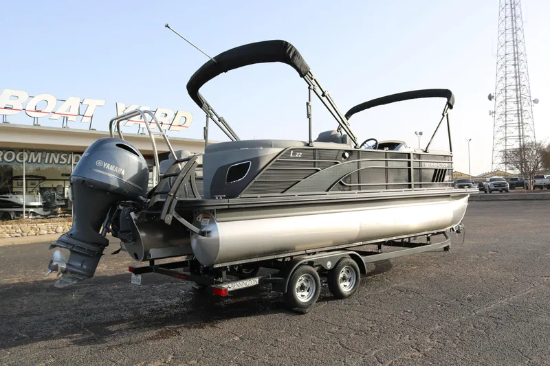 Slide: The Image of 2021 Bennington L22 pontoon boat on trailer, parked at a boat yard. - 7