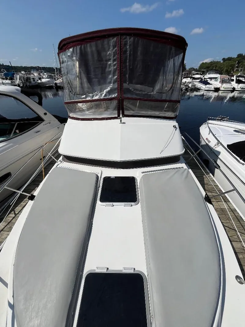 Slide: The Image of 1988 Carver 2767 SANTEGO boat docked at marina, featuring spacious deck and canopy. - 11