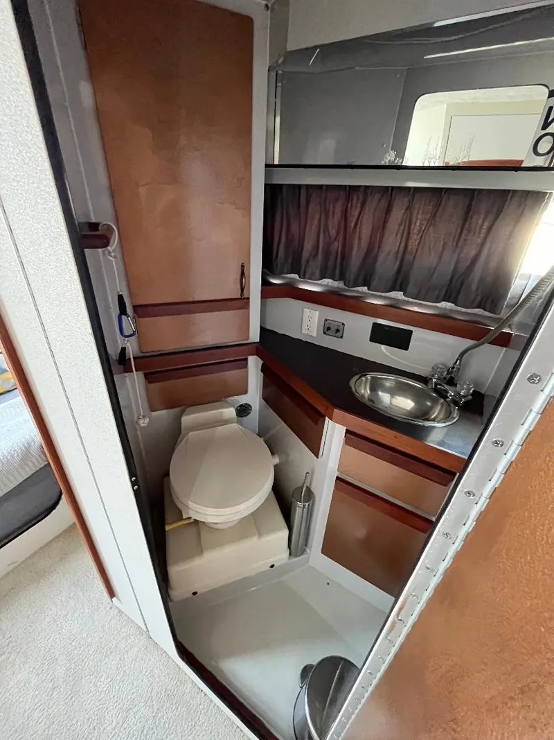 Slide: The Image of 1988 Carver 2767 Santego boat bathroom with sink, toilet, and storage. - 12