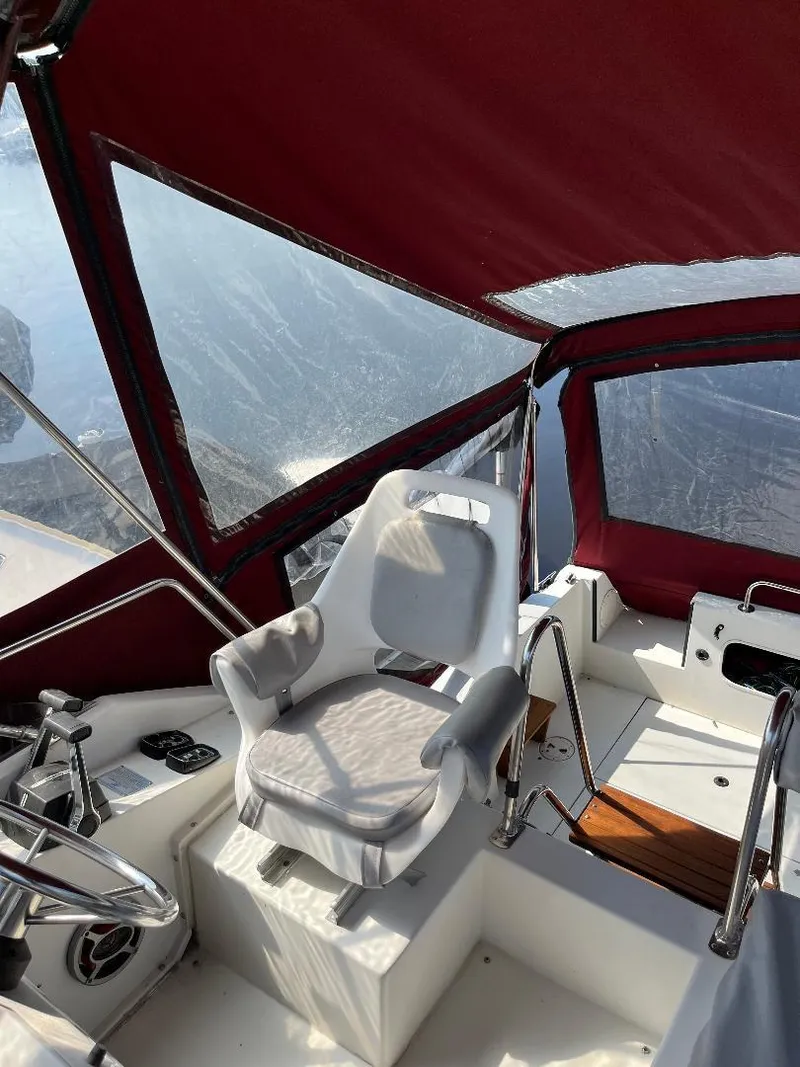 Slide: The Image of 1988 Carver 2767 Santego boat interior with red canopy and white captain's chair. - 16
