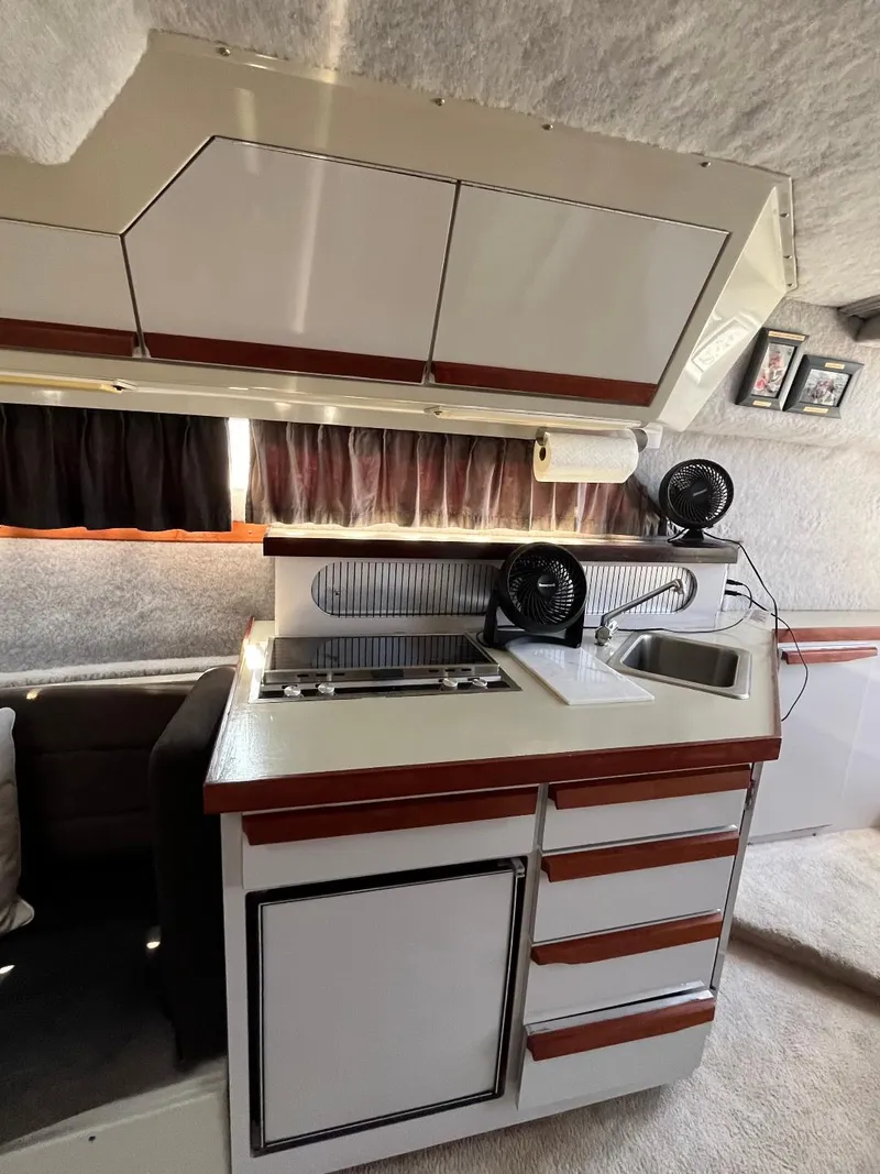 Slide: The Image of 1988 Carver 2767 Santego yacht interior kitchen with stove, sink, and storage cabinets. - 21