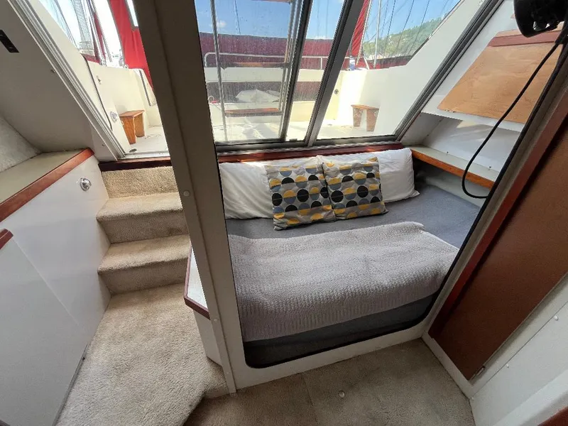 Slide: The Image of 1988 Carver 2767 Santego cabin interior with bed, stairs, and large windows. - 5