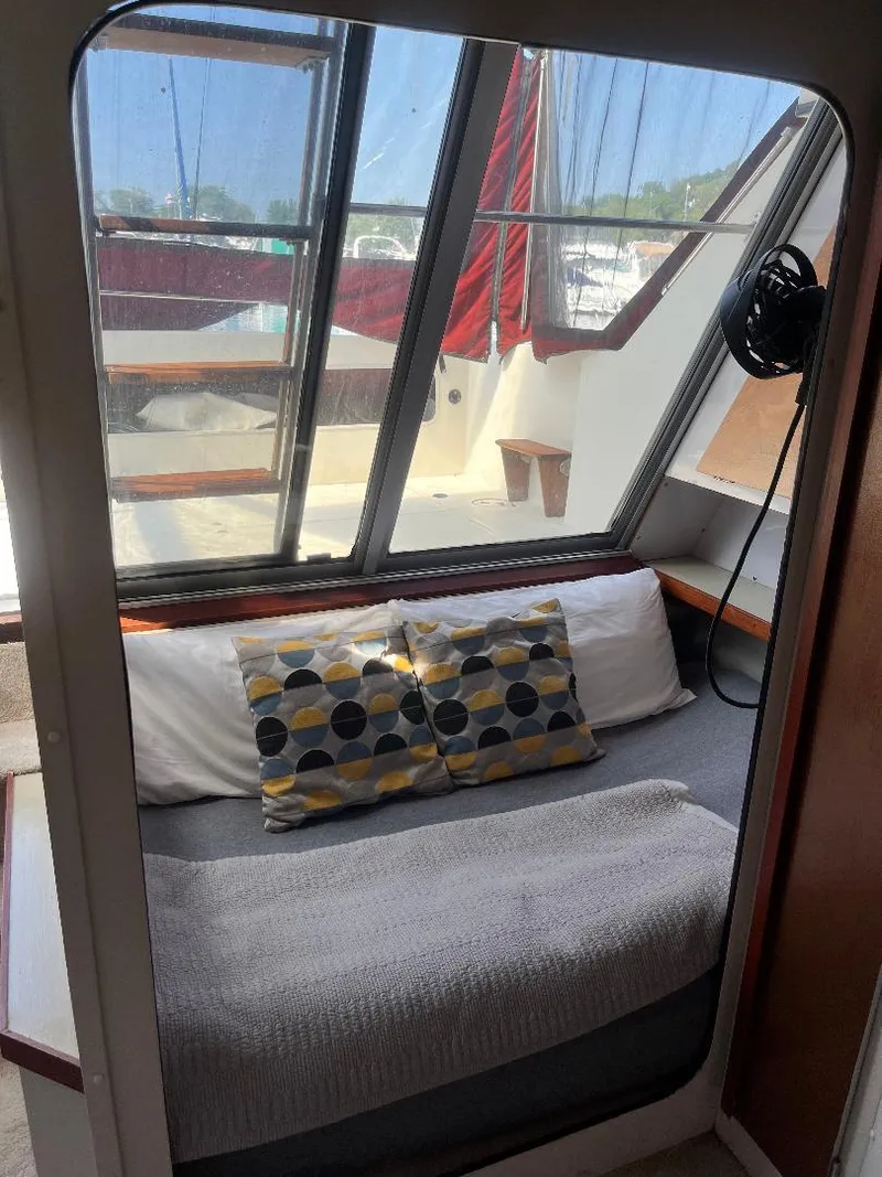 Slide: The Image of Cozy cabin interior of 1988 Carver 2767 Santego with pillows and large windows. - 7