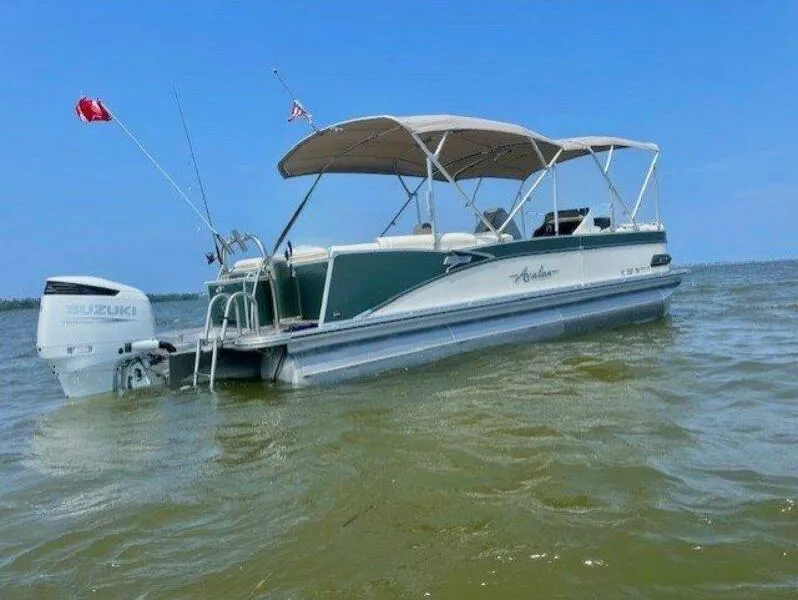 Slide: The Image of 2022 Avalon Catalina Platinum Quad Lounger boat on water, featuring Suzuki outboard motor. - 8