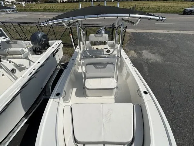 Slide: The Image of 2024 Parker 18 SE boat with T-top, docked on pavement, showcasing spacious interior. - 6