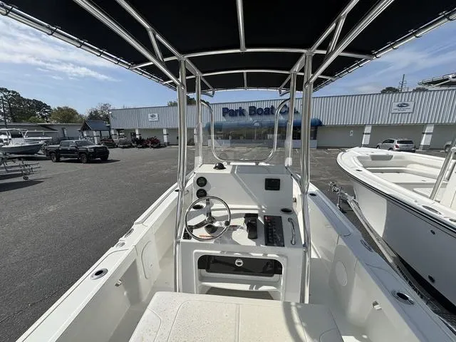 Slide: The Image of 2024 Parker 18 SE boat interior with steering wheel and controls, parked at a dealership. - 3