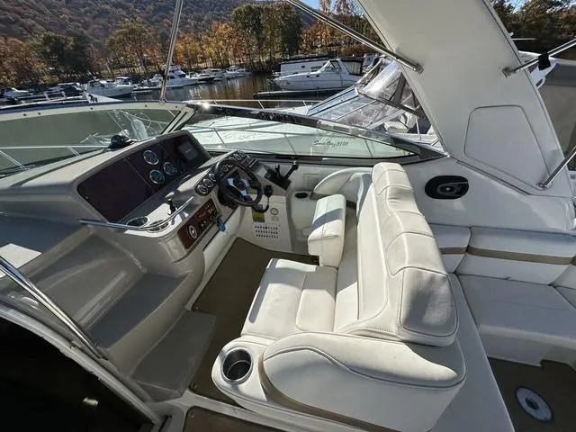 Slide: The Image of 2004 Formula 37PC yacht cockpit with white seating and control panel, docked near autumn trees. - 13