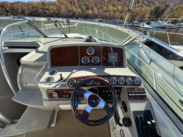 Slide: The Image of 2004 Formula 37PC boat cockpit with steering wheel, gauges, and controls, docked by a scenic lake. - 15