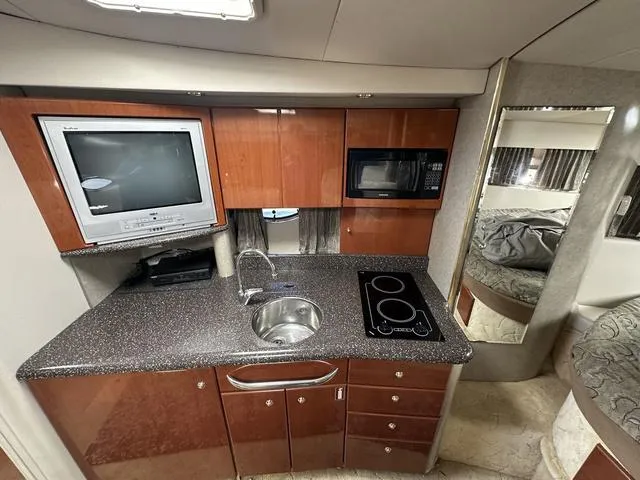 Slide: The Image of 2004 Formula 37PC yacht kitchen with TV, microwave, sink, and stove. - 23