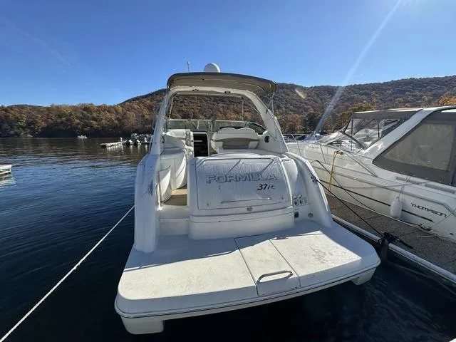Slide: The Image of 2004 Formula 37PC yacht docked on a sunny day, surrounded by scenic hills. - 8