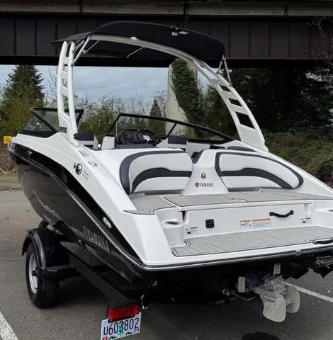 Slide: The Image of 2023 Yamaha Boats 195S, sleek design, black and white, parked on trailer. - 3