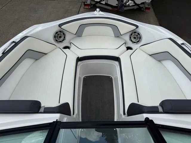 Slide: The Image of 2016 Yamaha Boats AR192 interior seating, white and black upholstery, in a parking lot. - 6