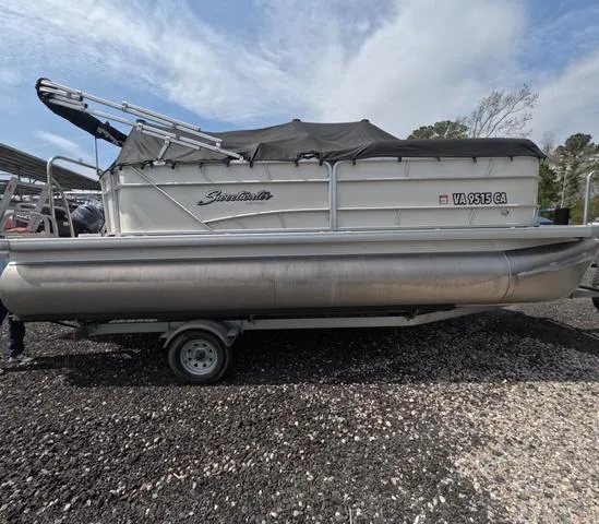 Slide: The Image of 2018 Sweetwater SW 2086 C pontoon boat with trailer, covered and parked on gravel. - 10
