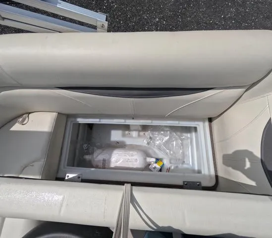 Slide: The Image of 2018 Sweetwater SW 2086 C boat storage compartment with cooler and bottles. - 21