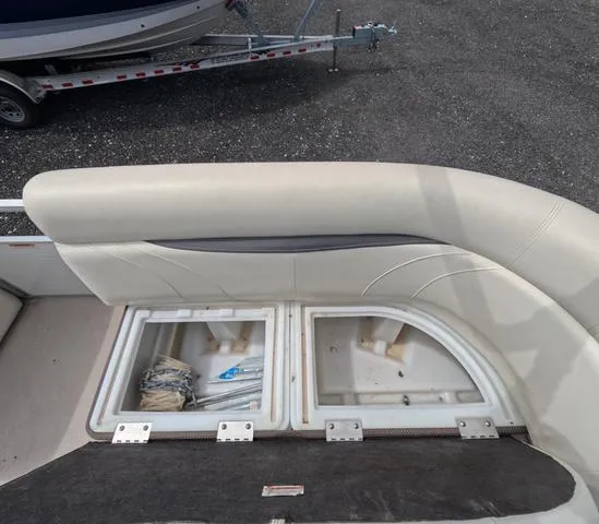 Slide: The Image of 2018 Sweetwater SW 2086 C boat interior storage compartments with trailer in background. - 32