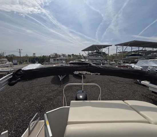 Slide: The Image of 2018 Sweetwater SW 2086 C pontoon boat with trailer, parked in a marina under a clear sky. - 38