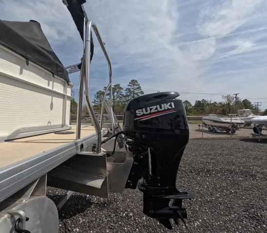 Slide: The Image of 2018 Sweetwater SW 2086 C boat with Suzuki outboard motor, parked on gravel lot. - 7