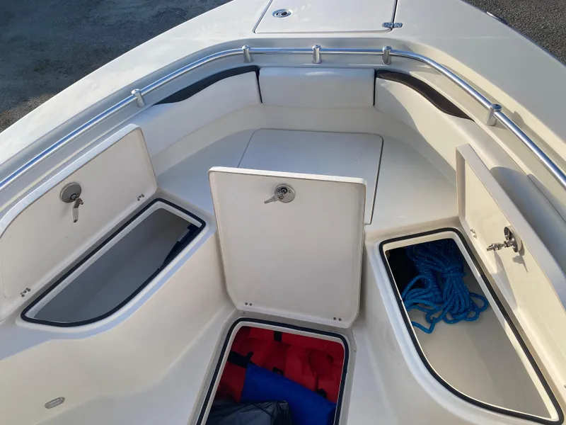 Slide: The Image of 2021 Cobia 237 Center Console boat storage compartments with safety gear and ropes. - 12