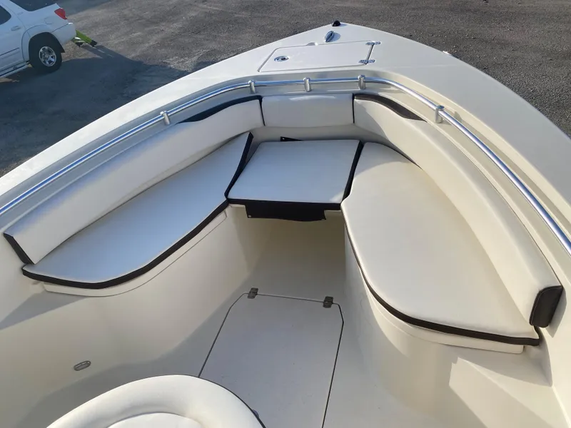 Slide: The Image of 2021 Cobia 237 Center Console boat with cushioned seating and table in the bow area. - 13