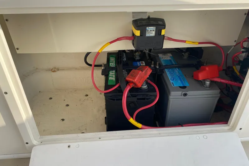 Slide: The Image of 2021 Cobia 237 Center Console battery compartment with wiring and connections. - 21