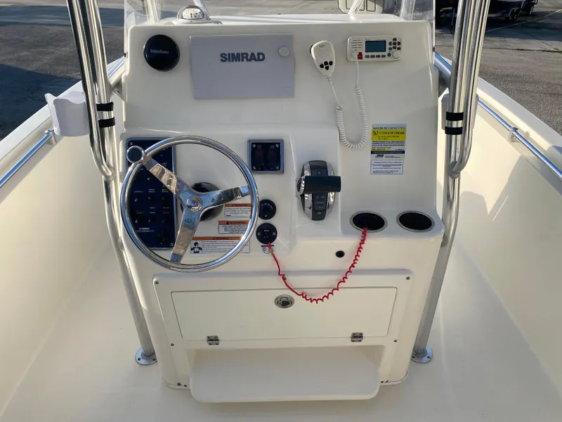 Slide: The Image of 2021 Cobia 237 Center Console boat dashboard with steering wheel and navigation equipment. - 22
