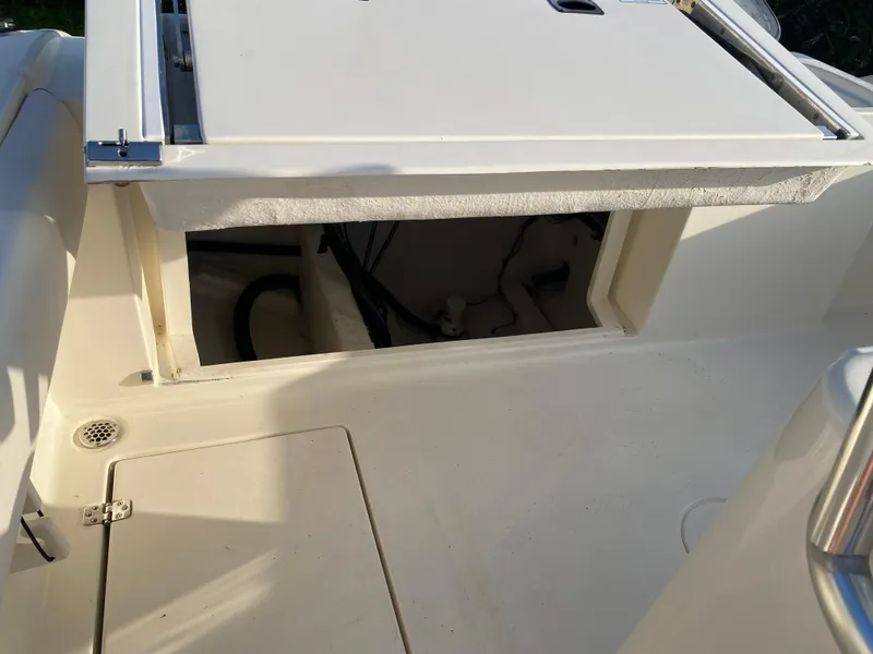 Slide: The Image of 2021 Cobia 237 Center Console boat storage compartment with open hatch. - 29