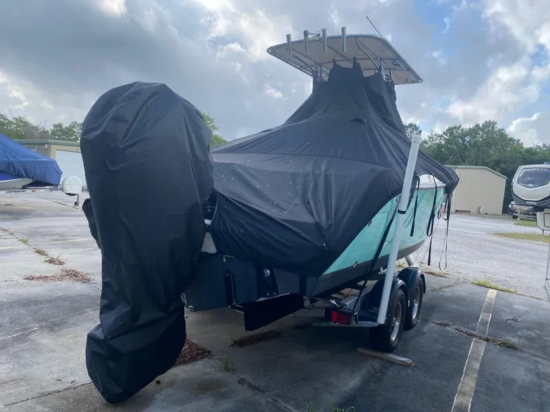 Slide: The Image of 2021 Cobia 237 Center Console boat covered on trailer, parked outdoors. - 35