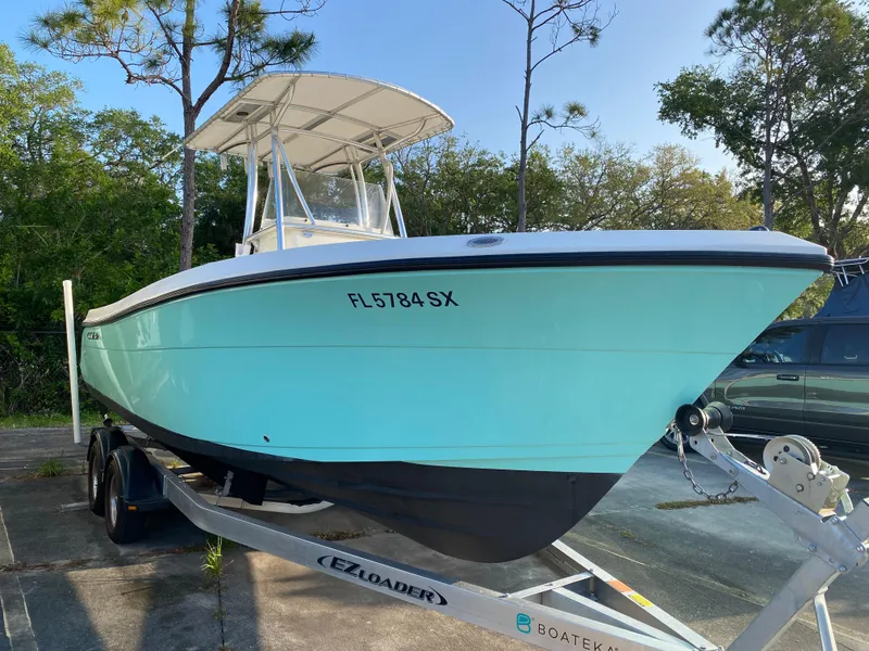 Slide: The Image of 2021 Cobia 237 Center Console boat on trailer, parked outdoors. - 6
