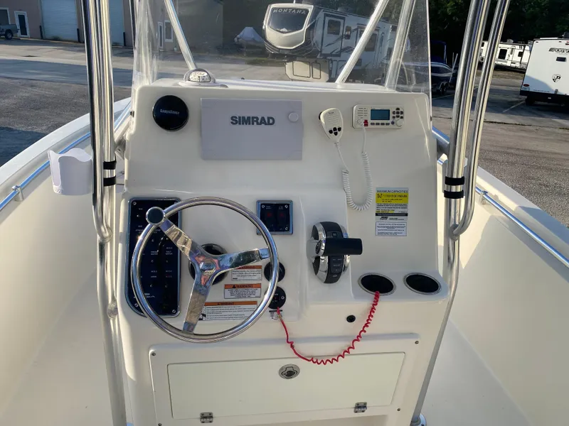 Slide: The Image of 2021 Cobia 237 Center Console boat dashboard with steering wheel and Simrad electronics. - 7