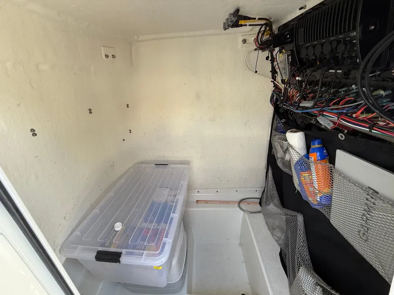 Slide: The Image of Interior storage of 2022 Parker 2801 Center Console boat with organized wiring and supplies. - 15